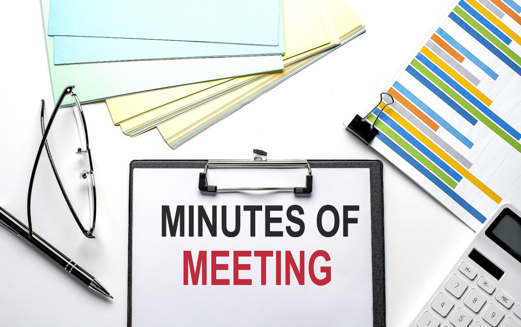 MEETING MINUTES text on the paper sheet with chart,color paper and calculator