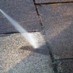 Power cleaning dirty floor, paving slabs with high pressure water jet. Cleaning with high pressure water jet. Cleaning service washing backyard and pavers with pressure water.